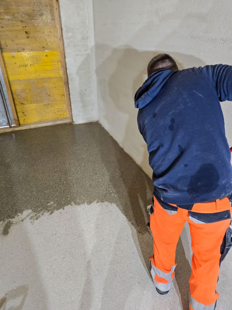 Ein Mitarbeiter der Johannes Roth GmbH bringt Wasserglas auf die vorbereitete Fläche auf