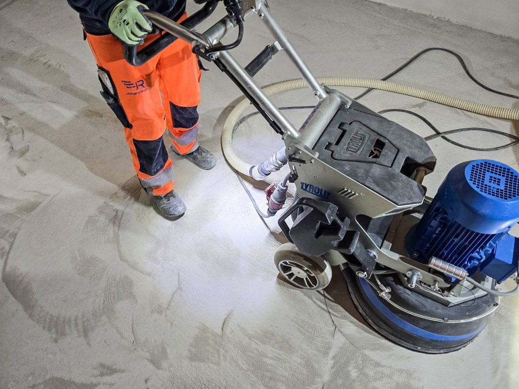 Die Betonfläche wird mit einer modernen Schleifmaschine bearbeitet.
